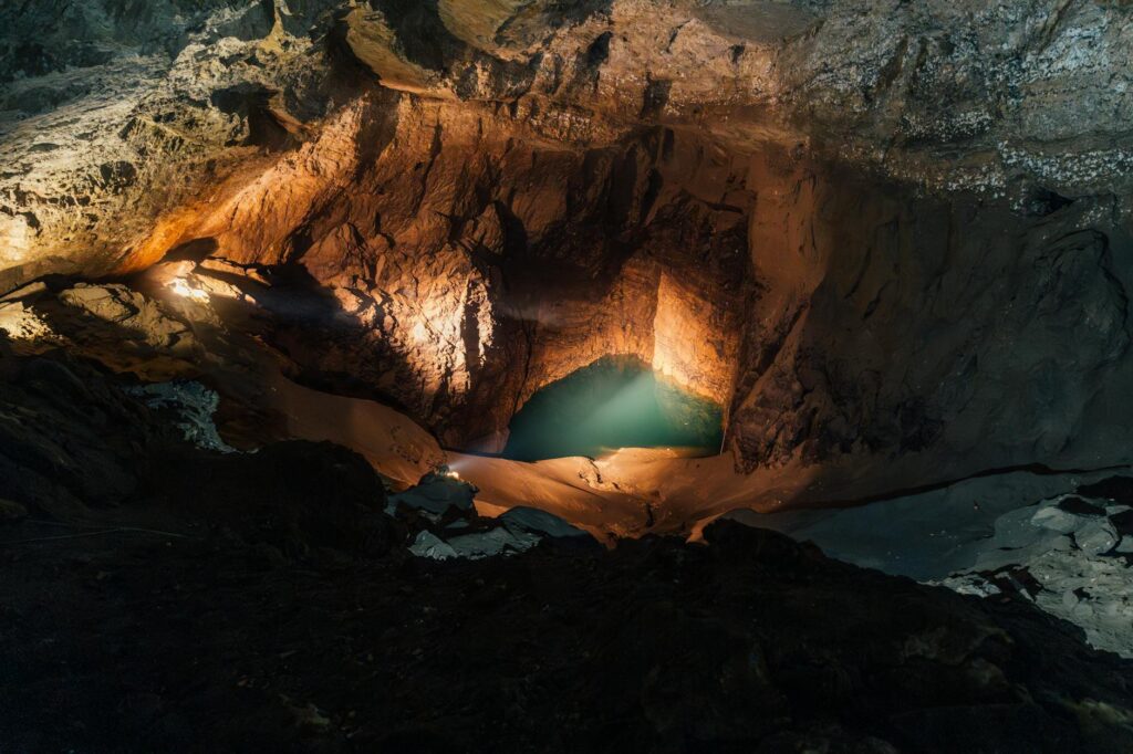 Discover the breathtaking beauty of an illuminated underground cave with a serene water pool in Новый Афон.